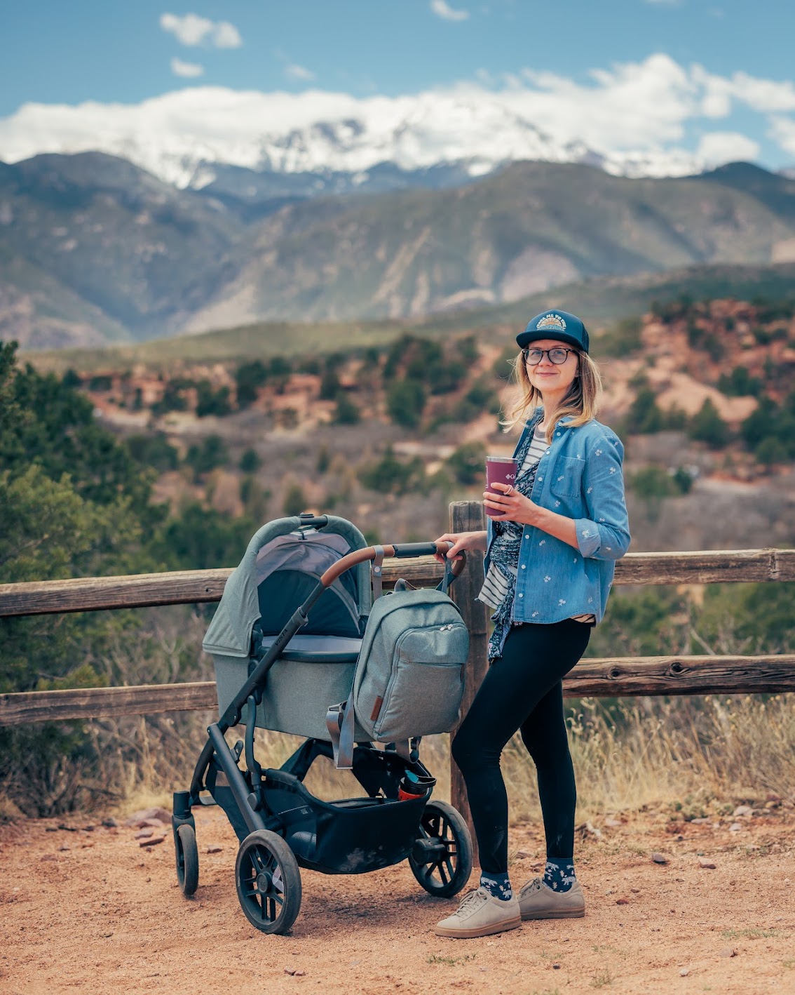 Ula smiling beside a stroller with mountain views behind her